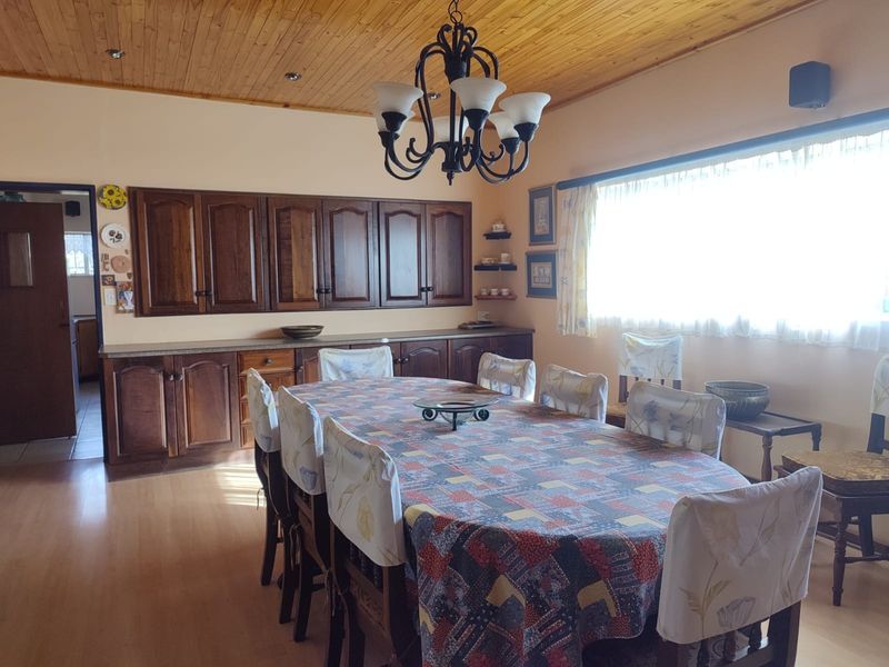 Dining room featuring timber ceiling, laminate flooring, and extensive built-in wooden cabinetry providing ample storage space.