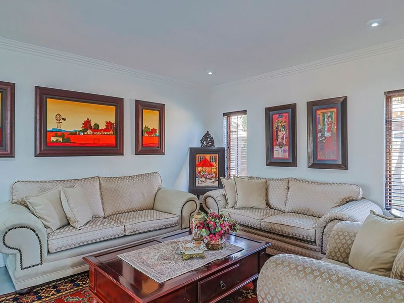 A well-maintained living room featuring crown molding, recessed downlighting, and venetian blinds, providing a bright and comfortable space.