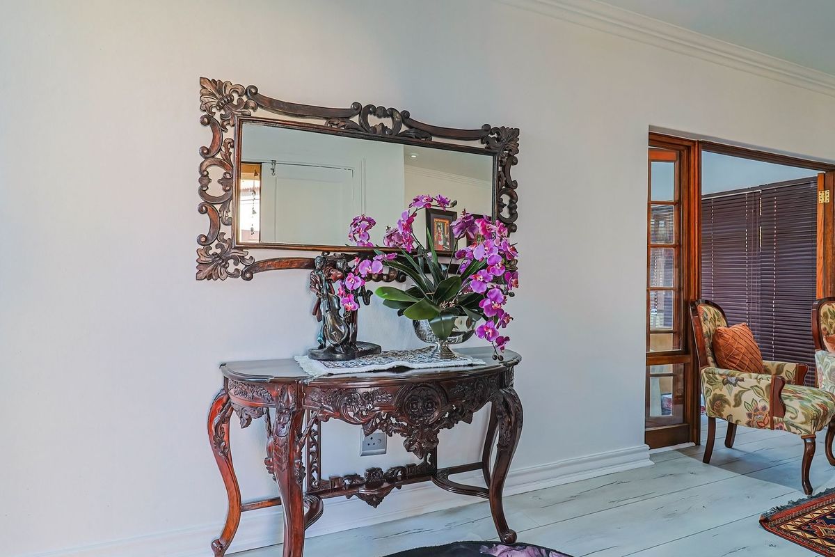 A well-maintained living area featuring classic timber-framed glass sliding doors, decorative coving, and neutral wall finishes.