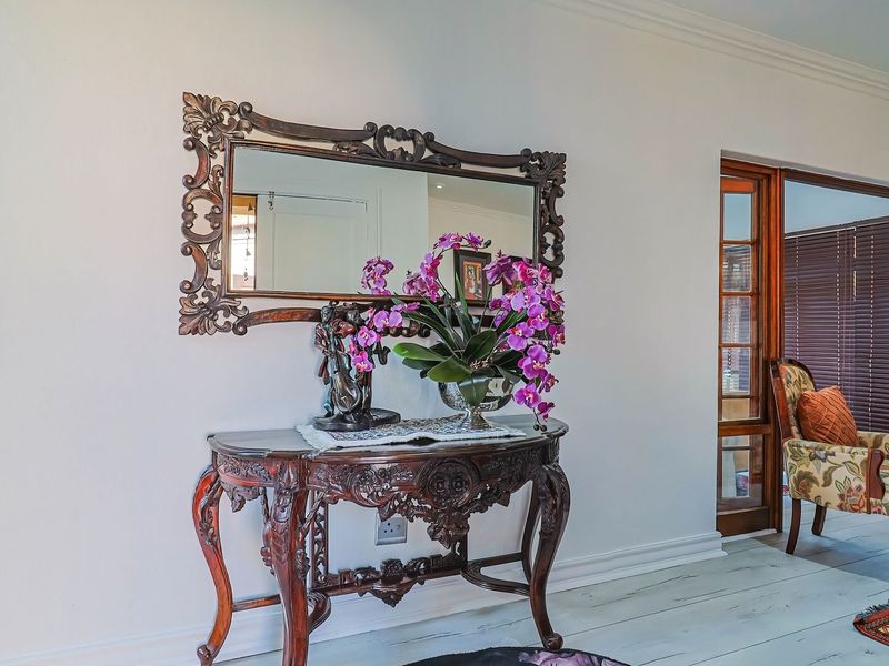 A well-maintained living area featuring classic timber-framed glass sliding doors, decorative coving, and neutral wall finishes.