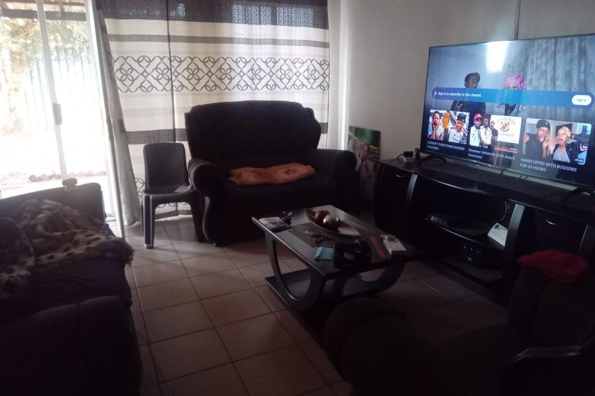 A living room featuring tiled flooring and a sliding glass door providing access to the exterior.