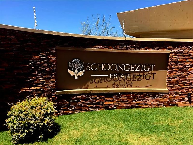 Entrance signage for Schoongezigt Estate featuring stone cladding and electric security fencing.