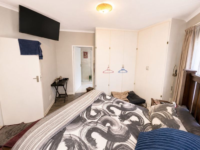 A bedroom featuring built-in cupboards and direct access to an en-suite bathroom.