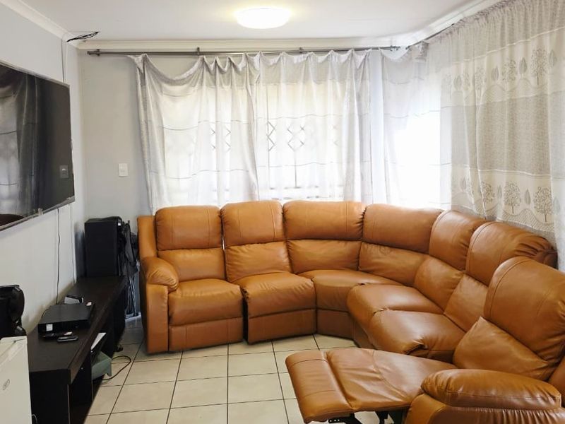 A functional living room featuring tiled flooring and neutral wall finishes, providing a comfortable space for relaxation.