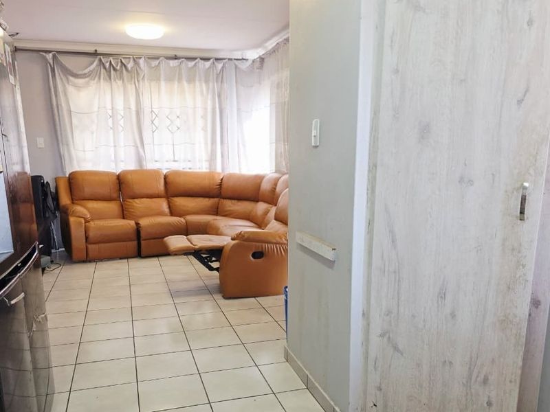 Open plan living area featuring ceramic tiled flooring and neutral wall finishes, providing a functional space connecting to the kitchen area.