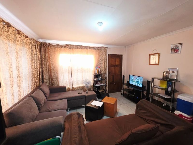 A living room featuring tiled flooring and coved ceiling cornices, providing a functional and lived-in space.