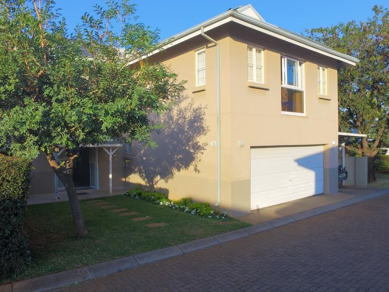 A well-maintained double-story residential property featuring a paved driveway, integrated garage, and neat front garden area.