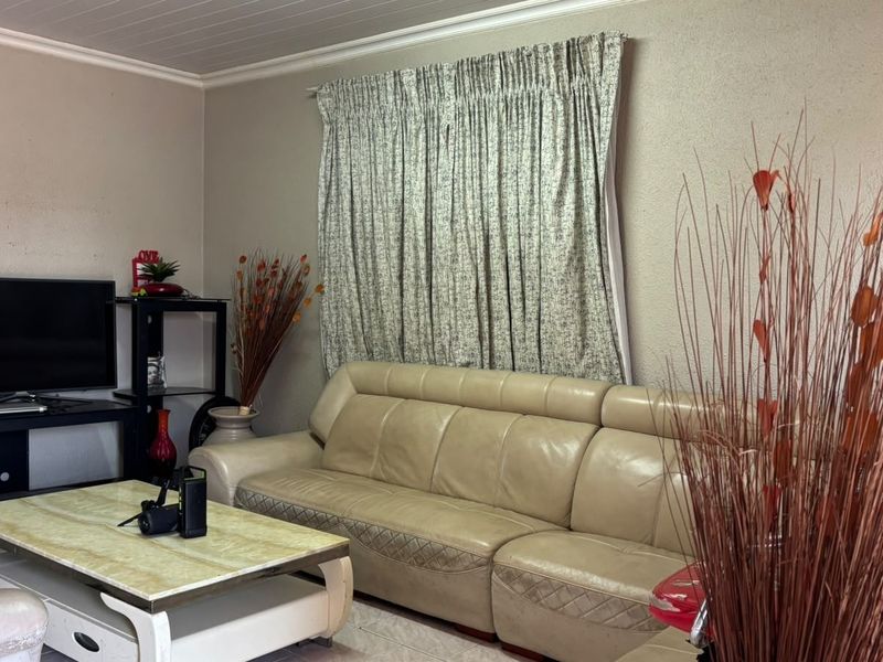 A living room featuring tiled flooring and coved ceiling details, providing a functional space for relaxation.