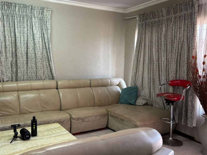 A living room area featuring tiled flooring and traditional cornicing, offering a blank canvas for potential interior updates and modernization.