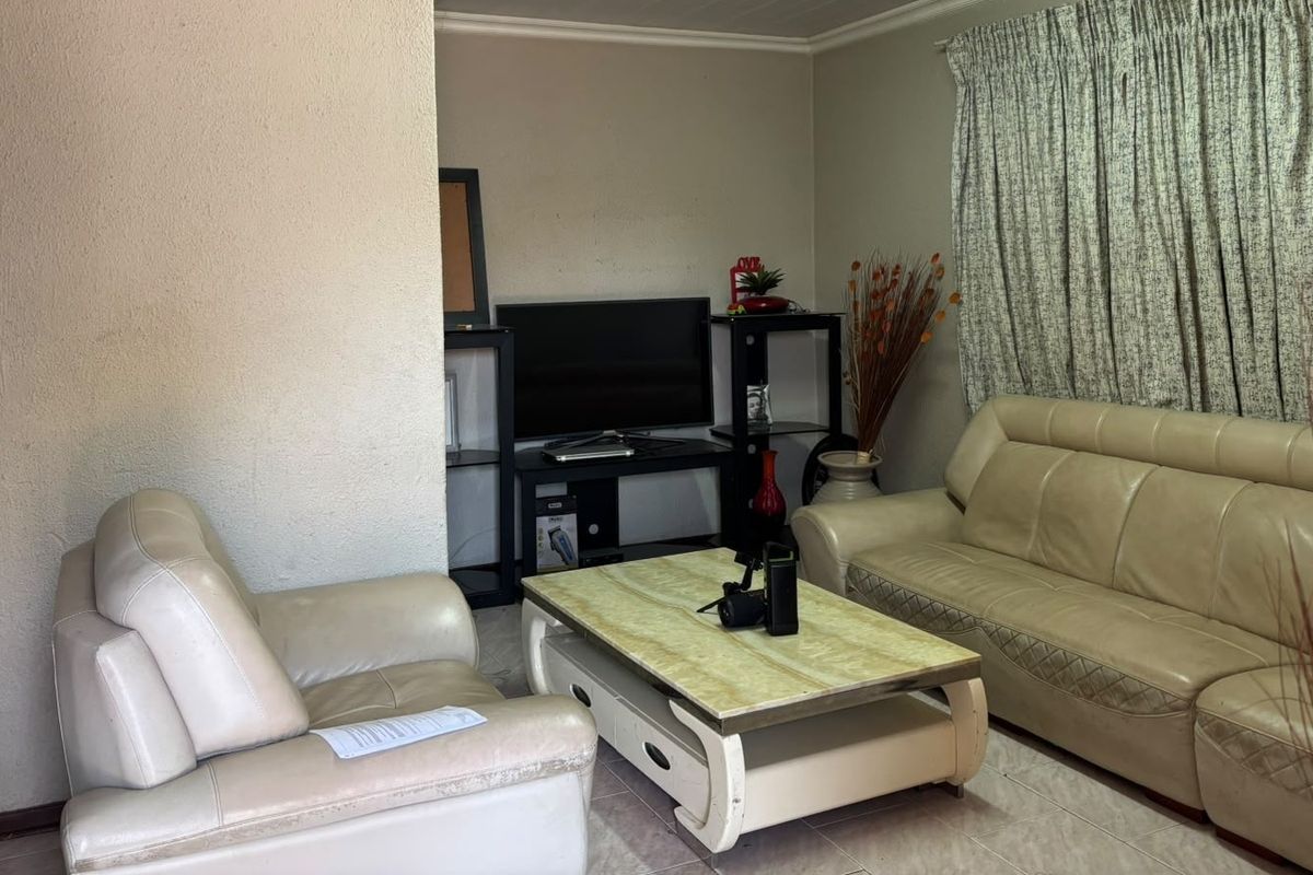 A living room featuring tiled flooring and coved ceiling details, providing a functional space for relaxation.