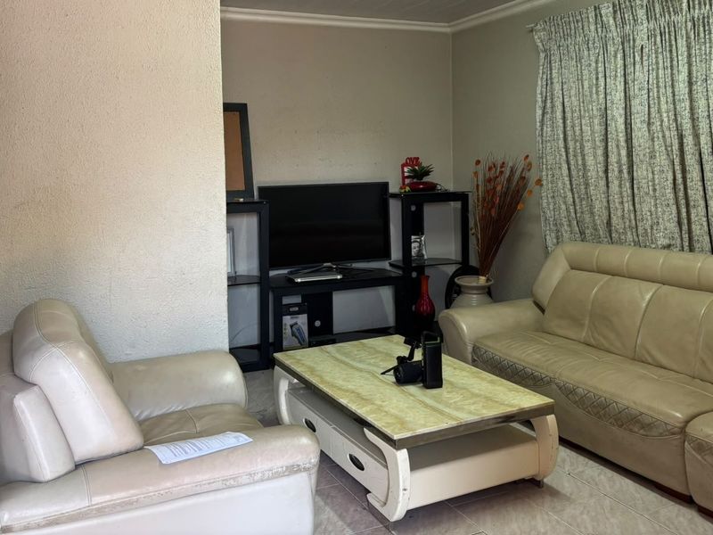 A living room featuring tiled flooring and coved ceiling details, providing a functional space for relaxation.