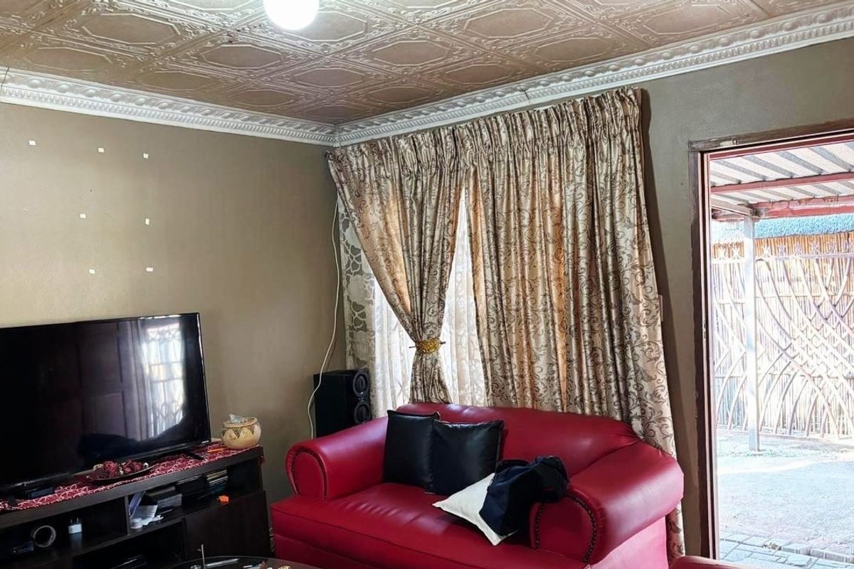 A living room featuring decorative ceiling tiles and crown molding, with direct access to an outdoor area.