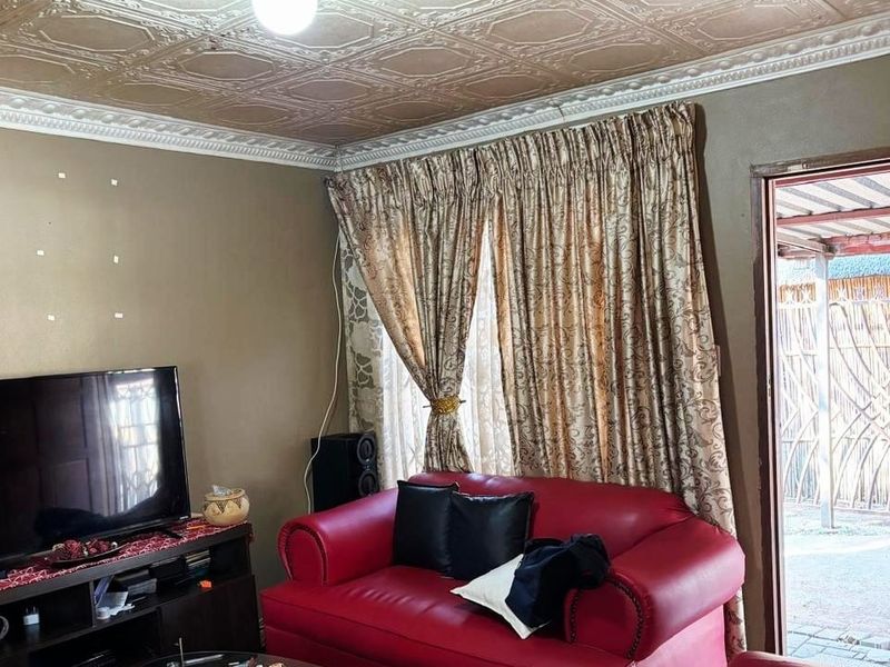 A living room featuring decorative ceiling tiles and crown molding, with direct access to an outdoor area.
