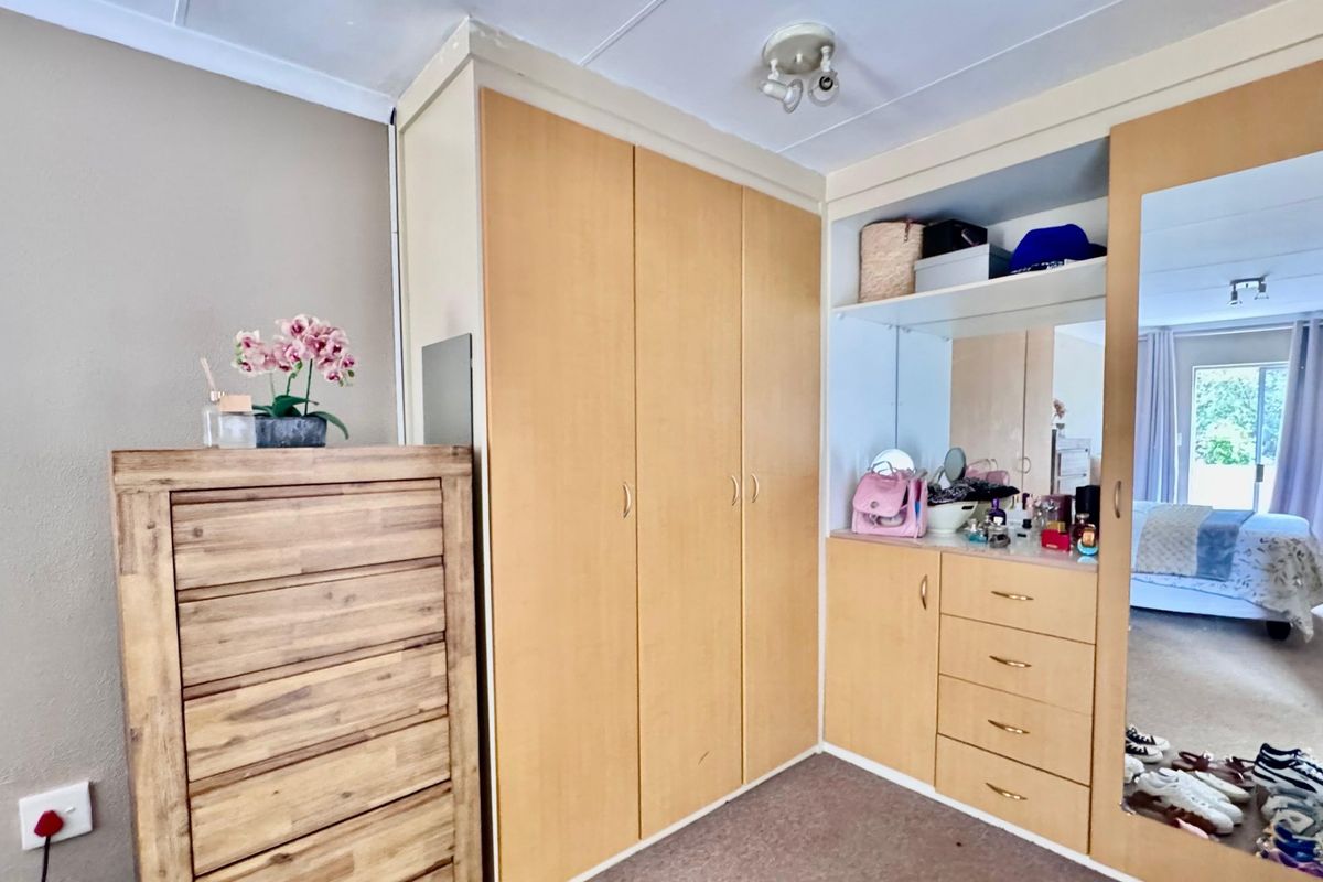 Bedroom featuring extensive built-in wooden cabinetry, including a vanity area with integrated mirror and ample storage space.