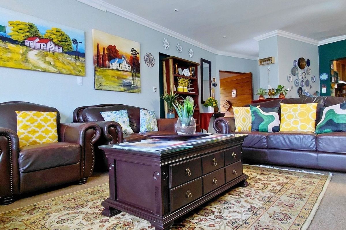 A comfortable living room featuring recessed downlighting and decorative cove cornicing, providing a warm and inviting atmosphere for relaxation.