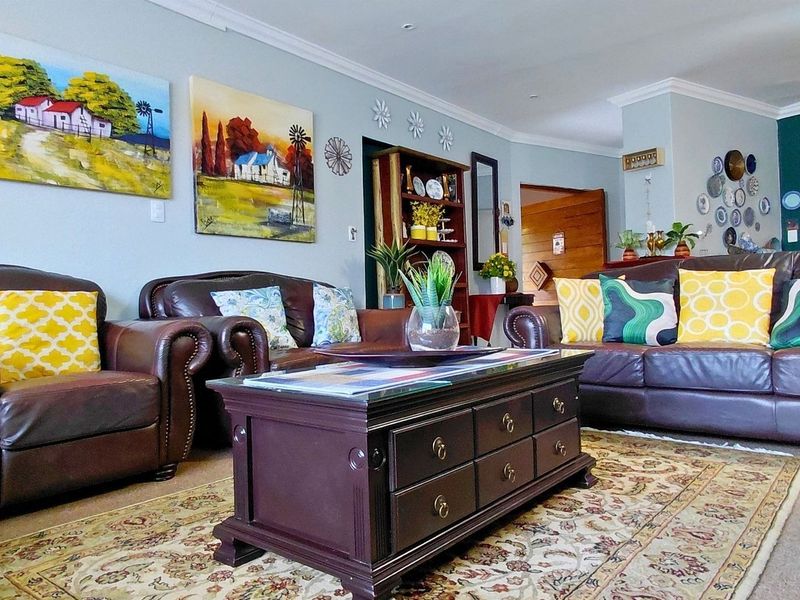 A comfortable living room featuring recessed downlighting and decorative cove cornicing, providing a warm and inviting atmosphere for relaxation.