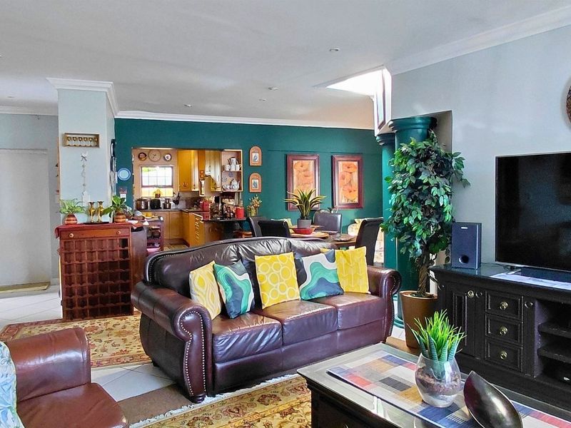 Spacious open-plan living area featuring tiled floors, recessed lighting, and a seamless flow into the adjacent kitchen space.