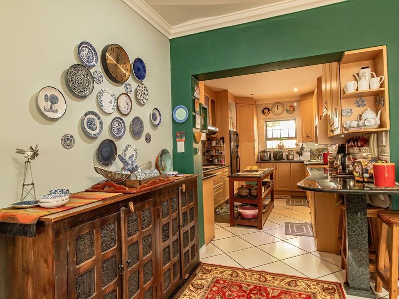 Open plan kitchen and dining area featuring wooden cabinetry, granite countertops, and ceramic tile flooring with a breakfast bar transition.