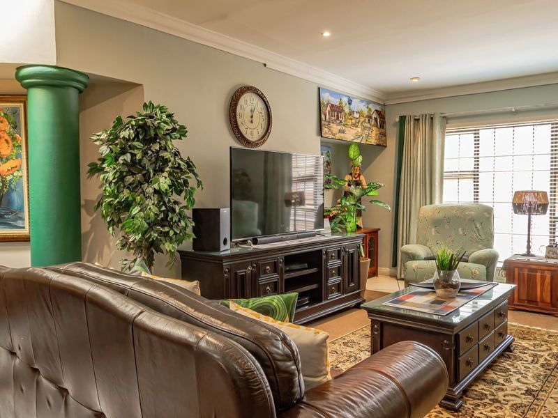A comfortable living room featuring a decorative column, recessed downlighting, and tiled flooring, offering a warm and inviting space for relaxation.