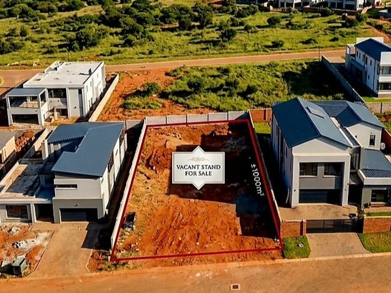 An aerial view of a vacant residential stand measuring approximately 1000 square meters, situated between two existing modern homes in a developed estate.