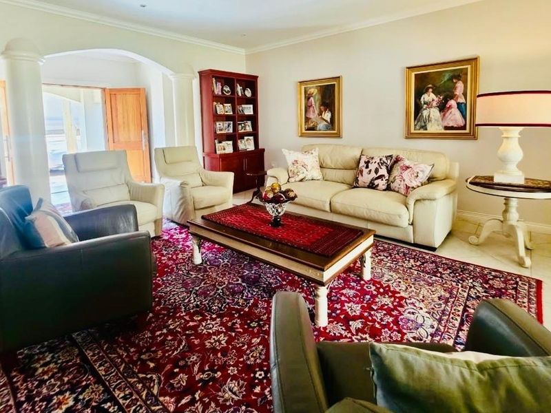 A spacious living room featuring tiled flooring, an elegant archway leading to an entrance, and recessed ceiling lighting.