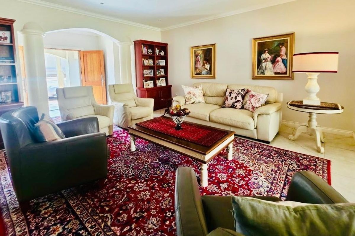 A spacious living room featuring tiled flooring, an elegant archway leading to an entrance, and recessed ceiling lighting.