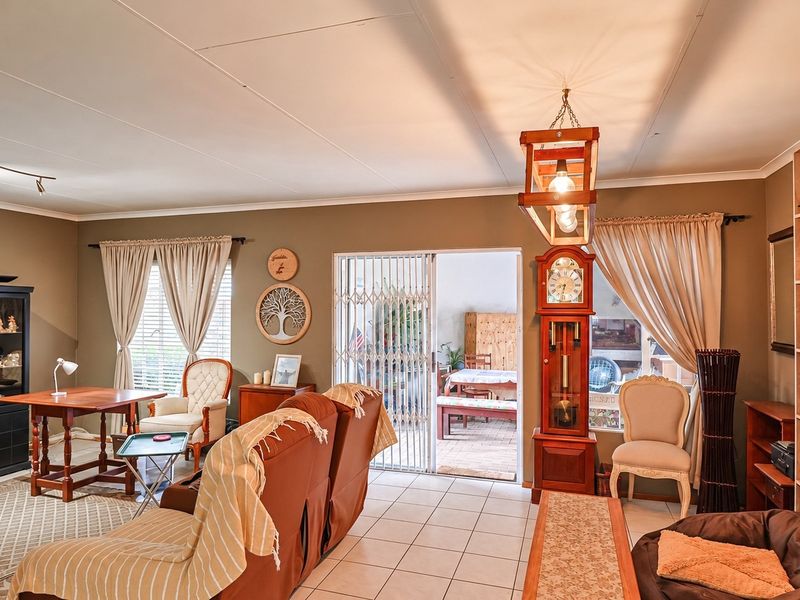 Spacious living room featuring tiled flooring, a split-system air conditioner, and a sliding glass door providing access to the outdoor patio area.