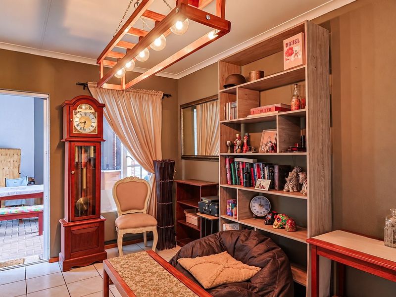 A living room area featuring tiled flooring and a sliding glass door providing access to an outdoor patio space.