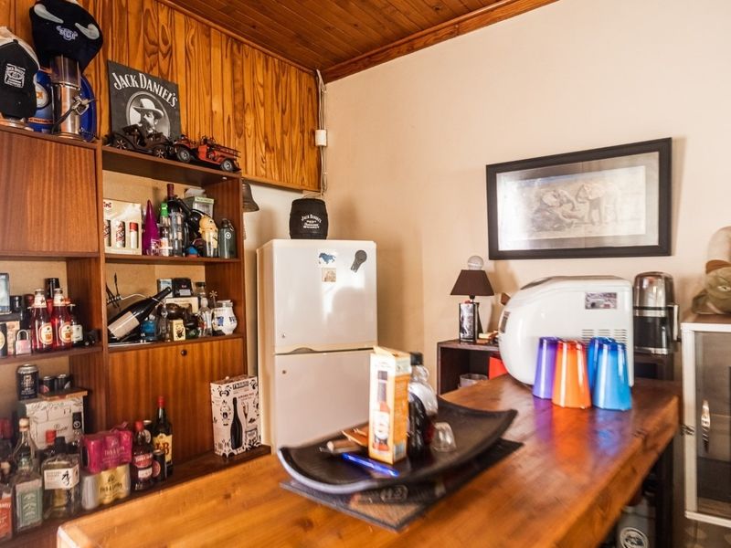A dedicated home bar area featuring built-in wooden cabinetry and a wooden ceiling, providing a rustic entertainment space.