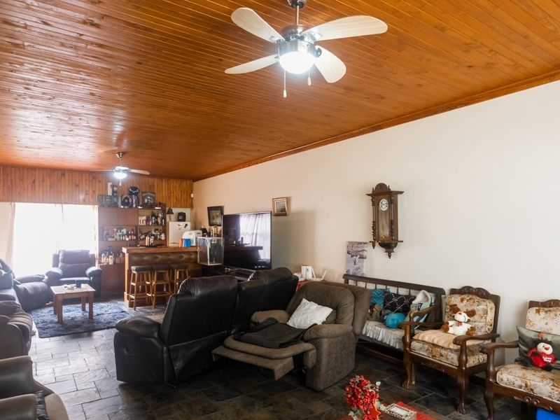 Spacious living area featuring a distinctive timber tongue and groove ceiling, slate tile flooring, and a built-in bar area.