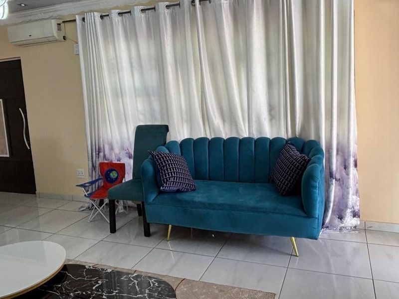 A living room featuring tiled flooring, recessed ceiling lighting, and a wall-mounted split-system air conditioner.