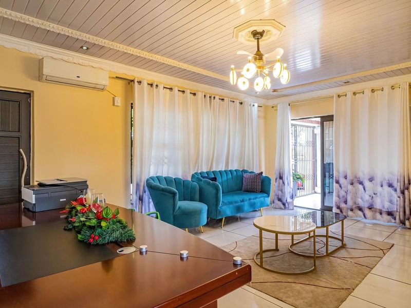 A spacious living area featuring tiled flooring, coved ceilings, an air conditioning unit, and direct access to an outdoor patio through sliding glass doors.