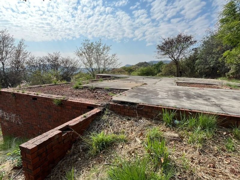 Vacant residential land featuring an existing concrete slab foundation and brick retaining walls, situated in a natural, elevated setting.