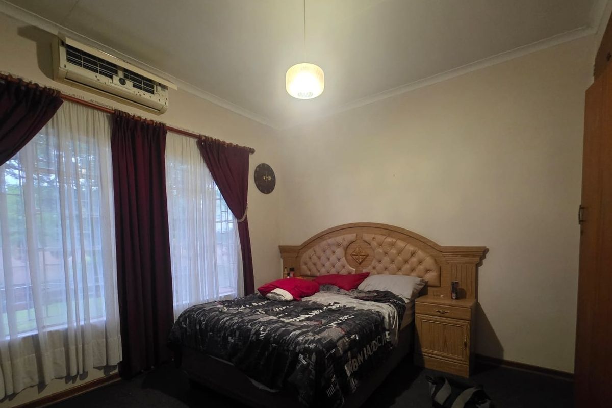 A bedroom featuring a wall-mounted air conditioning unit, built-in wardrobe, and coving detail.