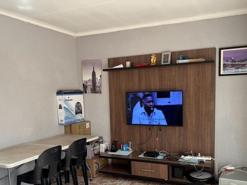 A living room featuring a built-in wooden media unit and neutral wall finishes.