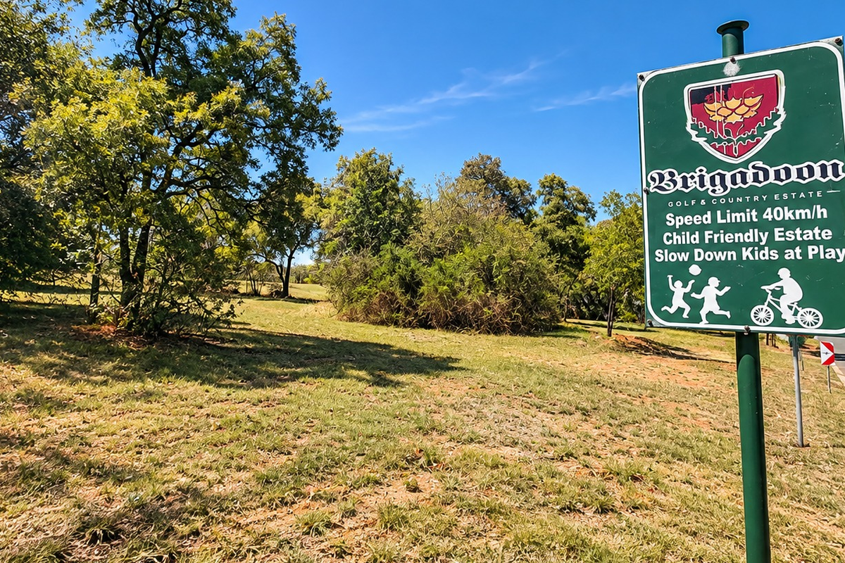 A view of the entrance area to the Brigadoon Golf and Country Estate, featuring established trees and open green space.