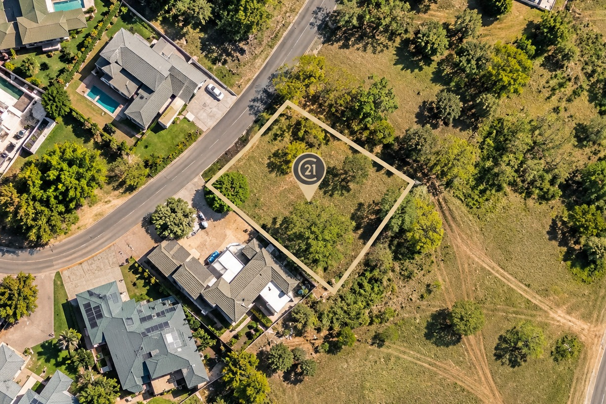 An aerial view of a vacant residential plot of land situated within a developed neighborhood, highlighting its location and boundaries.