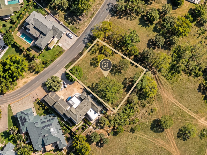 An aerial view of a vacant residential plot of land situated within a developed neighborhood, highlighting its location and boundaries.