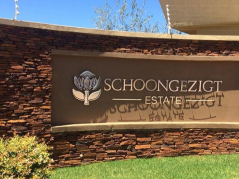 The entrance signage wall for Schoongezigt Estate, featuring decorative stone cladding and integrated security electric fencing.