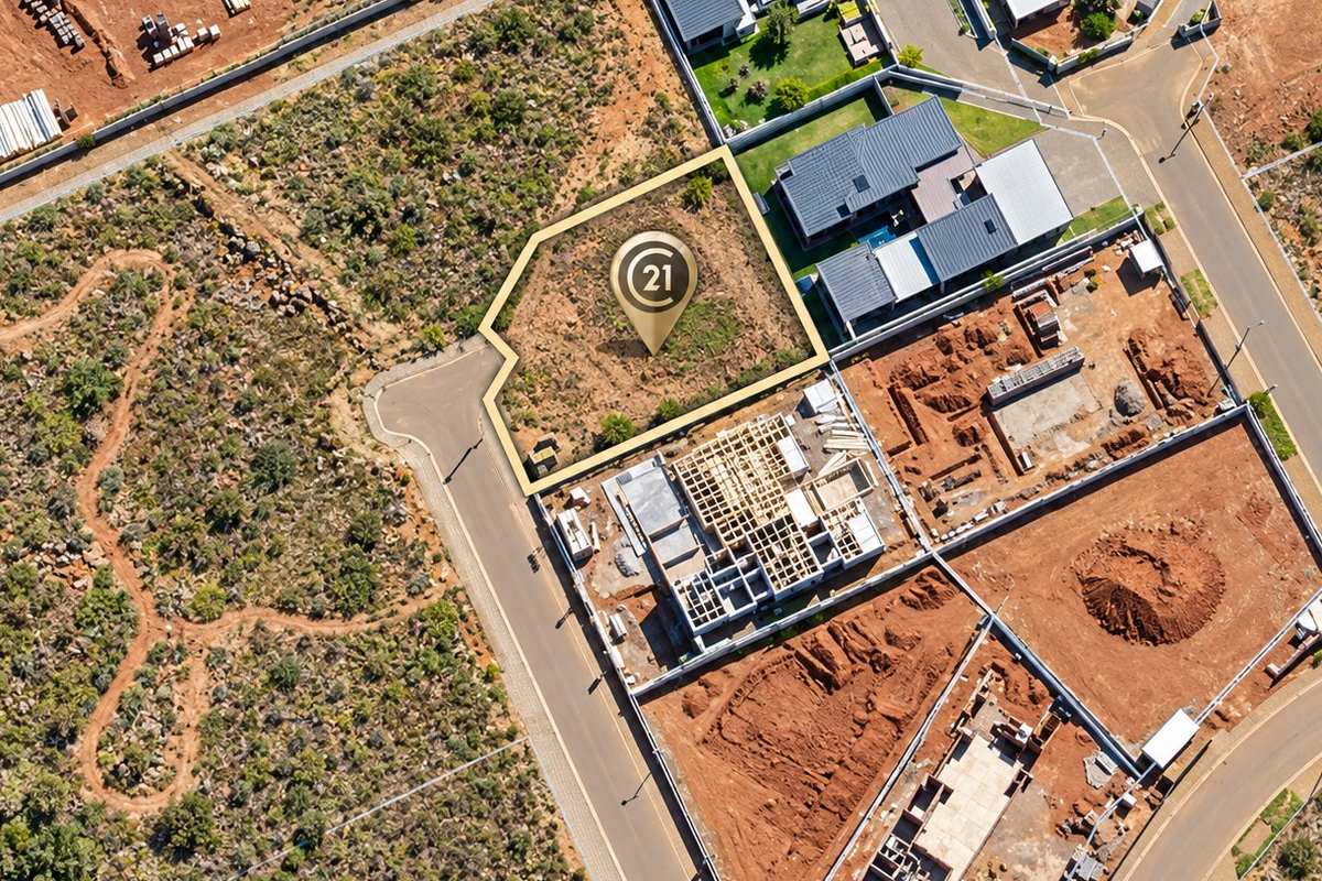 Aerial view of a vacant residential plot in a developing estate, highlighting the property boundaries and surrounding infrastructure.