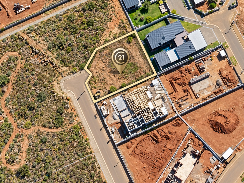Aerial view of a vacant residential plot in a developing estate, highlighting the property boundaries and surrounding infrastructure.