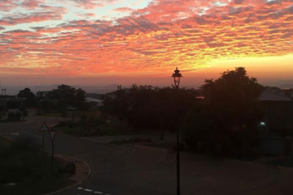 A scenic view of the neighbourhood at sunset, featuring a clear sky and local street infrastructure.