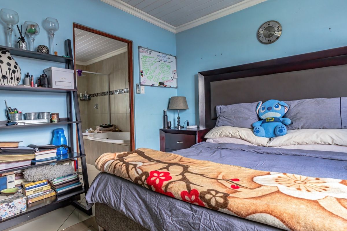 A bedroom featuring tiled flooring, a timber ceiling, and direct access to an en-suite bathroom.