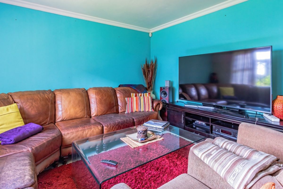 A living room featuring bright blue walls, coving, and skirting boards, providing a functional space for relaxation.