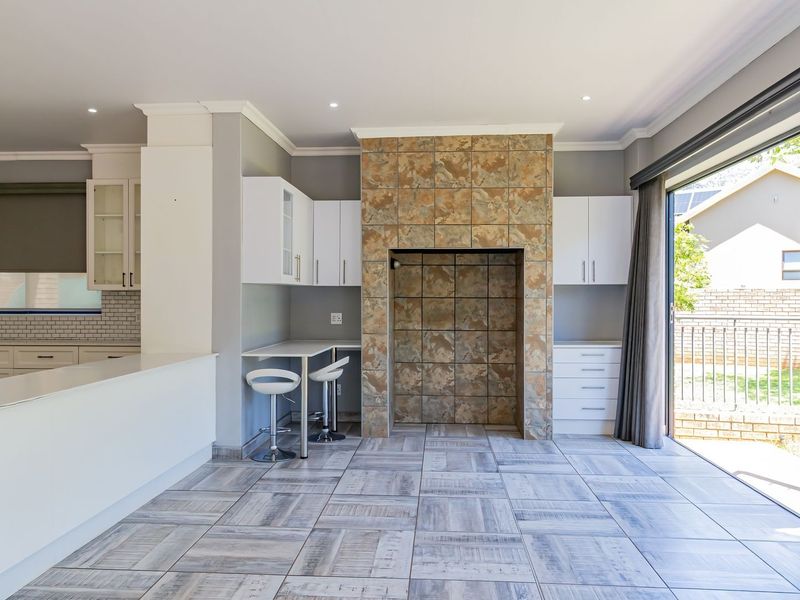 Spacious open-plan living area featuring a tiled fireplace, modern cabinetry, and large bi-fold doors that open to the garden.