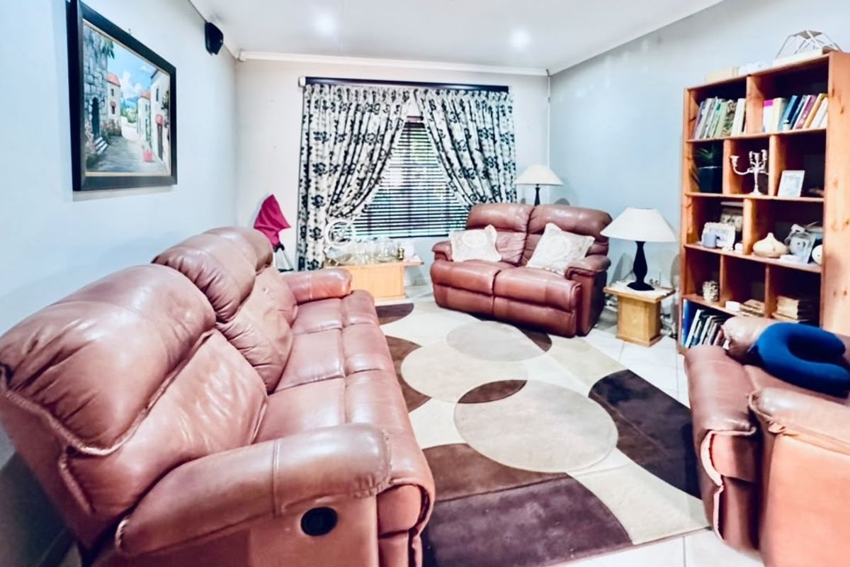 A comfortable living room featuring tiled flooring and recessed downlighting, providing a functional and inviting space for relaxation.