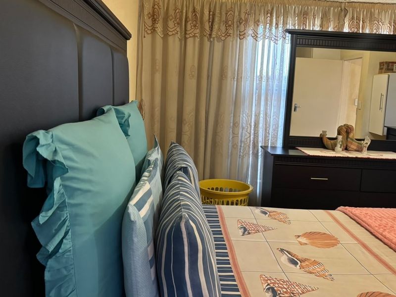 A bedroom featuring a window with installed curtain rails, providing natural light and a functional layout for a sleeping space.