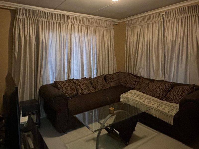 A living room area featuring tiled flooring and neutral wall tones, providing a functional space for relaxation.