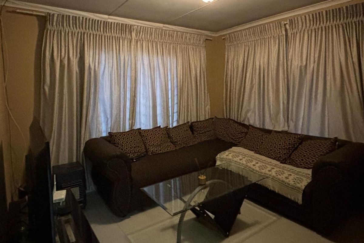 A living room area featuring tiled flooring and neutral wall tones, providing a functional space for relaxation.