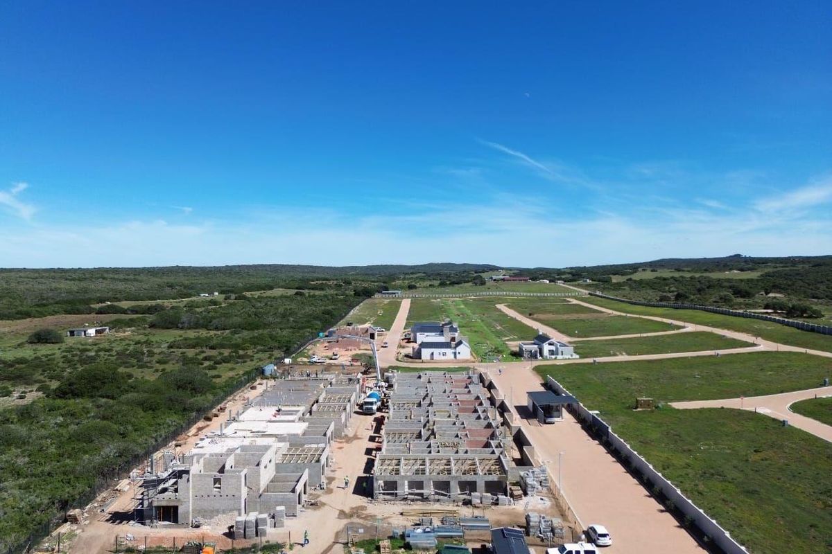 Aerial view of a residential development site showing multiple properties under construction with established road infrastructure and perimeter fencing.